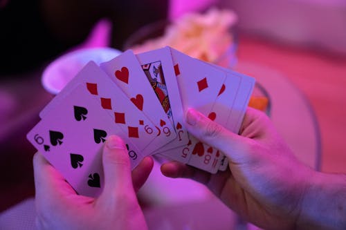 Hands of a Person Holding Playing Cards