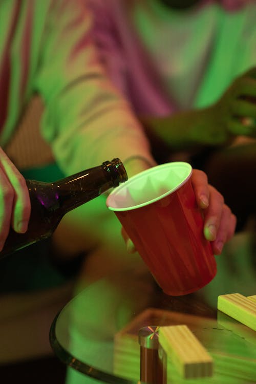 A Person Pouring Beer in a Red Cup