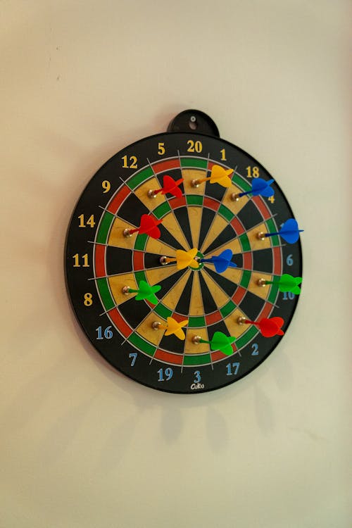 A Dartboard on the Wall with Colorful Darts 
