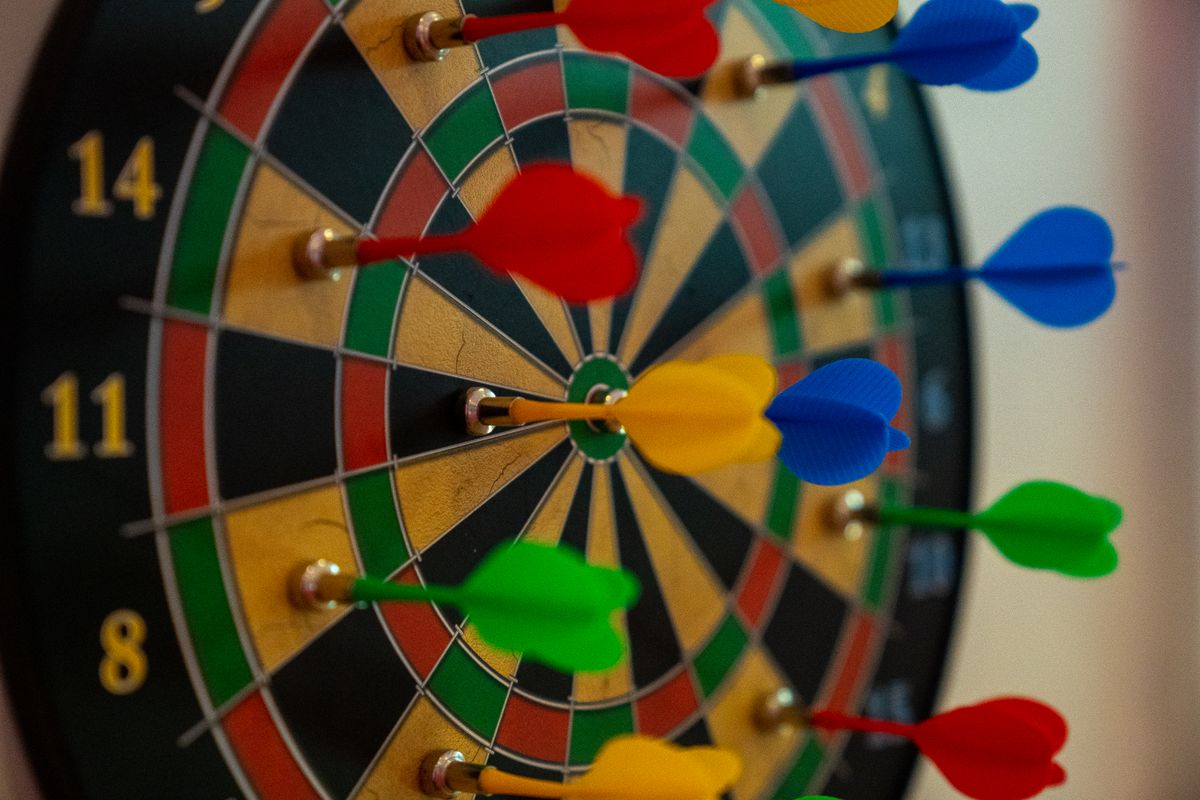 Kleurrijk dartbord met meerdere dartpijlen erin