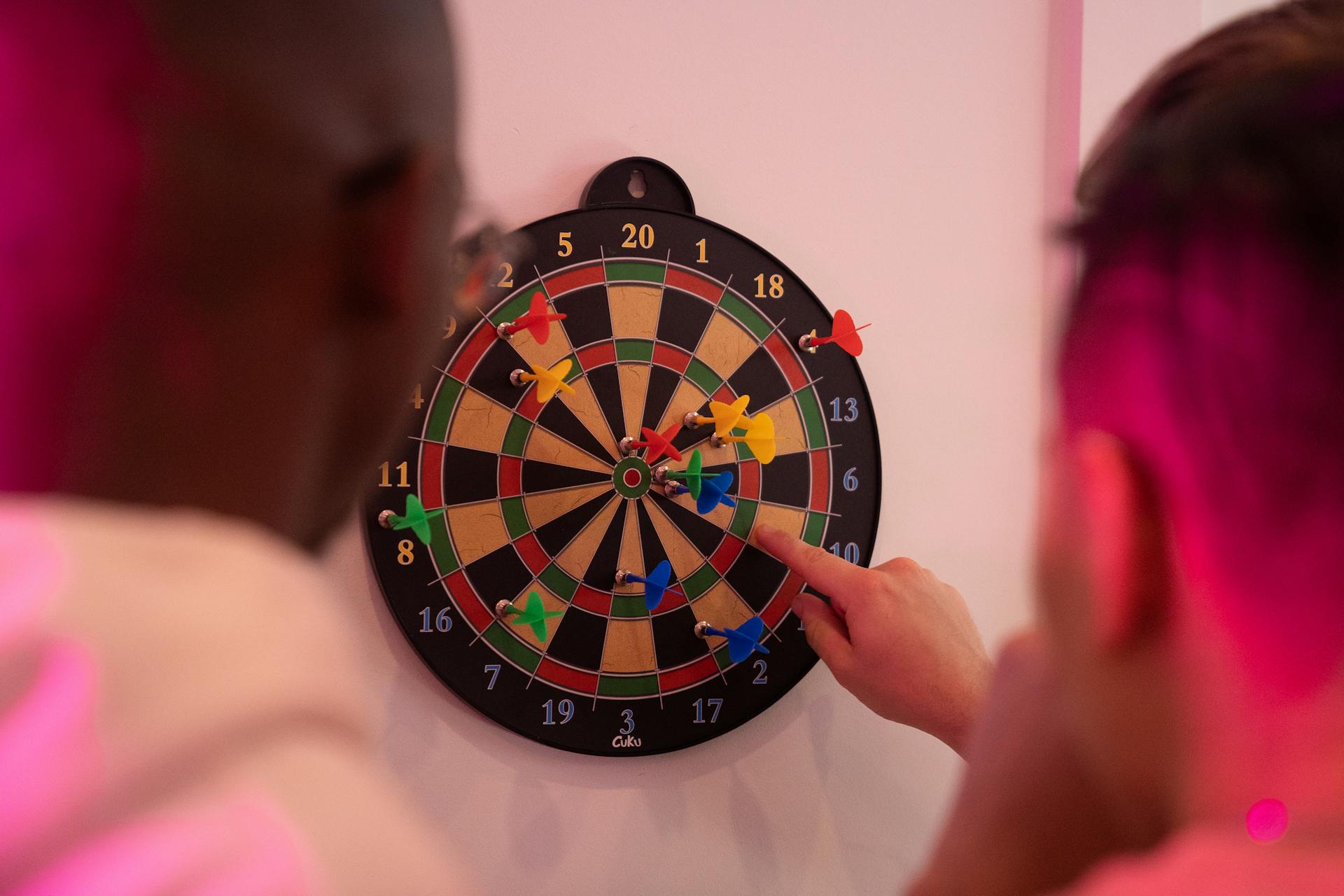 A Person Pointing to a Dart Board