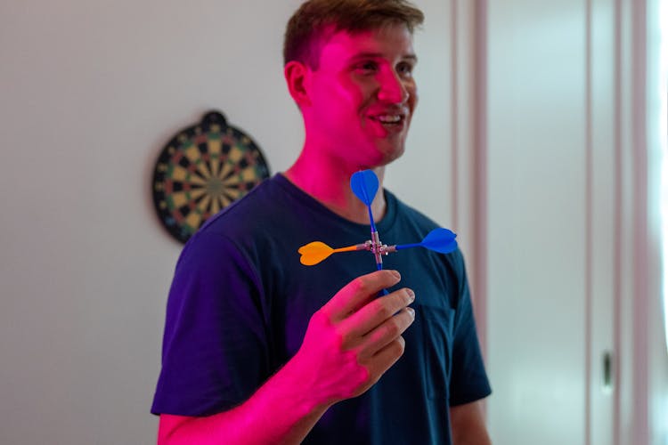 A Man Holding Magnetic Darts