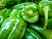 绿甜椒堆在一起，充满活力，展现出新鲜感和质感