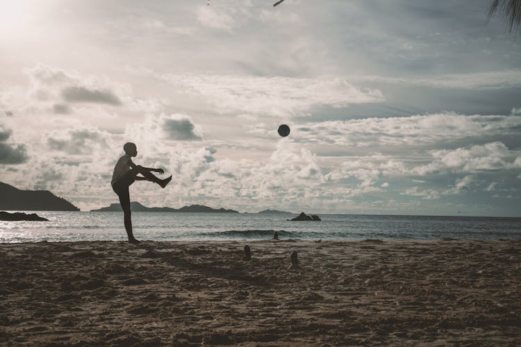 A Silhouette Person Playing On Shore