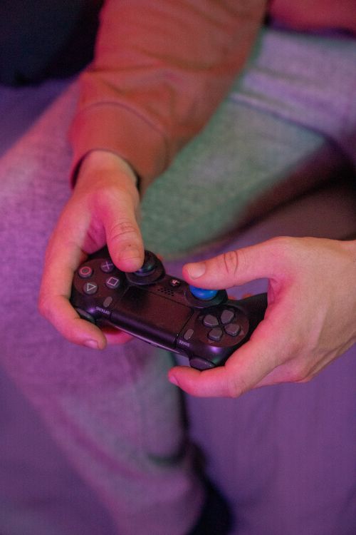 Free A person playing a video game using a black controller in a cozy indoor setting. Stock Photo