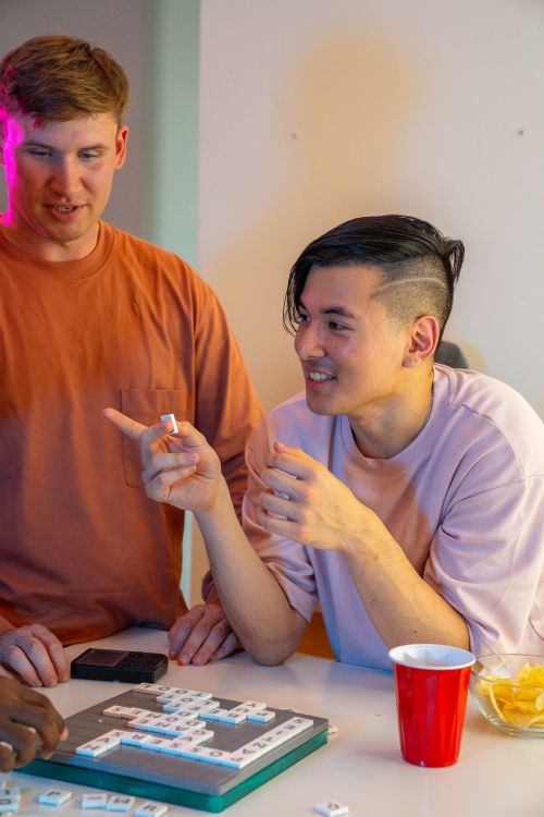 Free Two friends having fun during a game night with tiles and red cups. Stock Photo