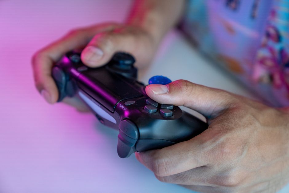 A detailed shot of hands gripping a video game controller, ideal for gaming themes.
