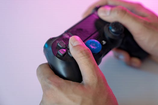 Close-up shot of hands gripping a black gaming controller with a blue thumbstick cover under neon lighting.