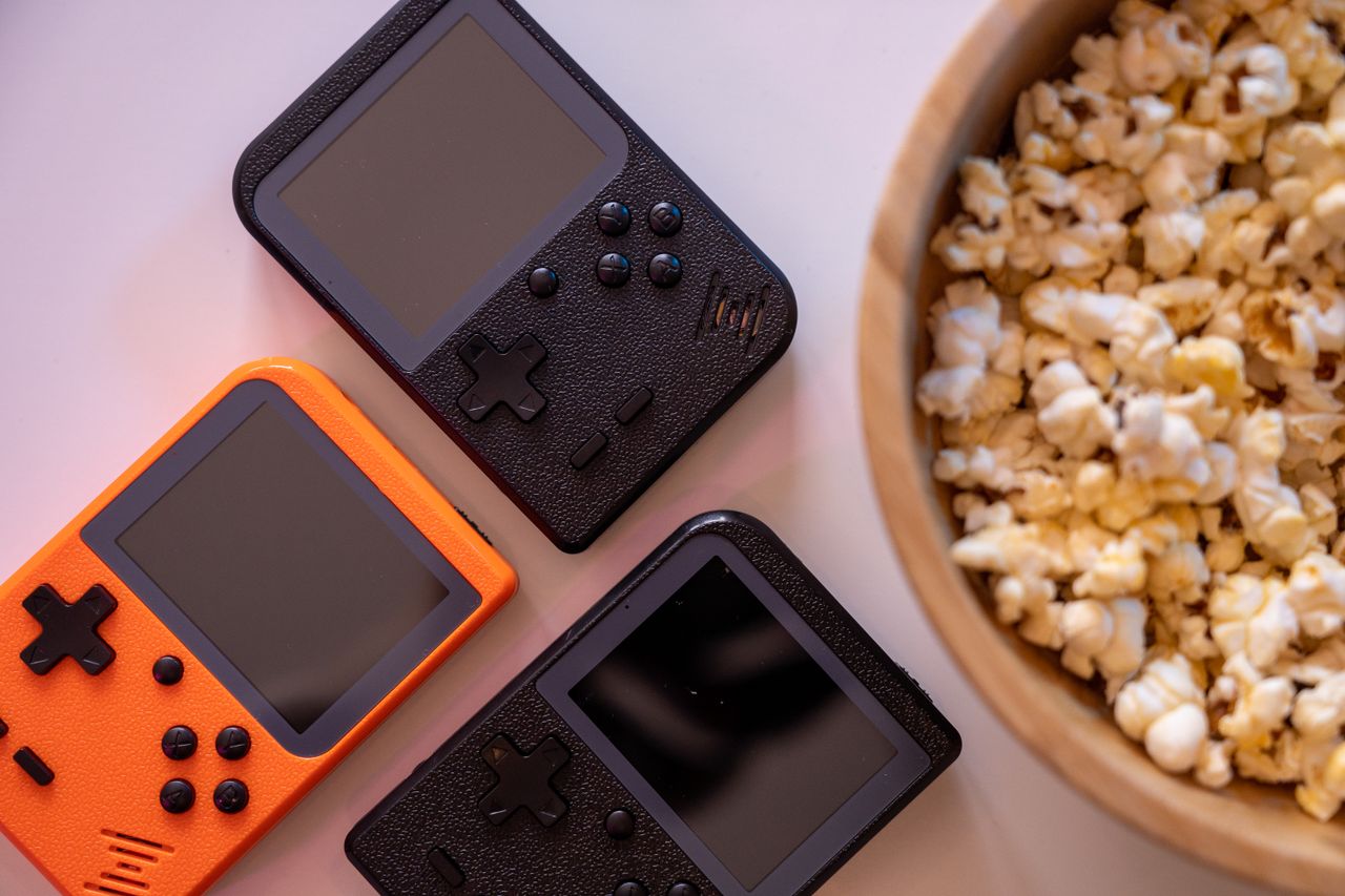close up of retro handheld game consoles and popcorn perfect for gamin