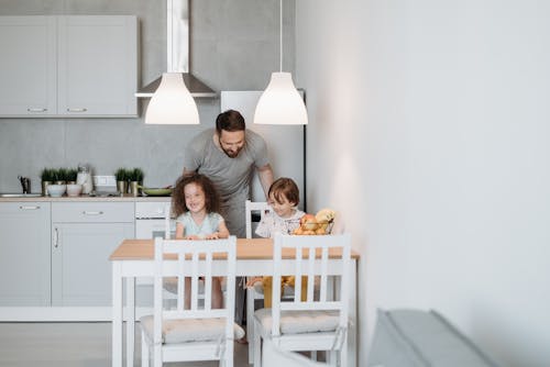 Free A Man Having Conversation with His Kids Inside the Kitchen Stock Photo
