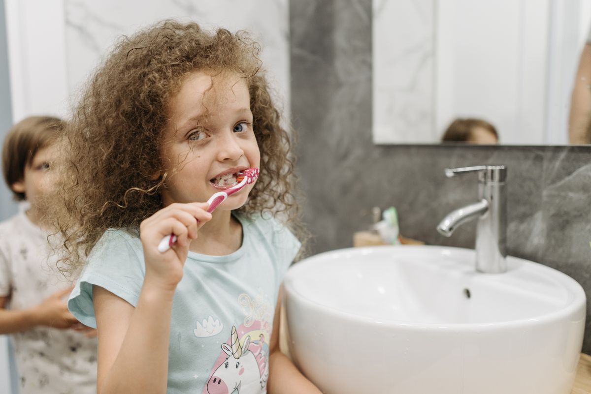Young child smiling with a missing front tooth
