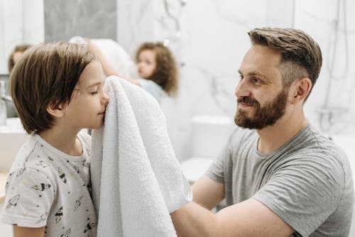Free A Father using Towel to Wipe his Son Stock Photo