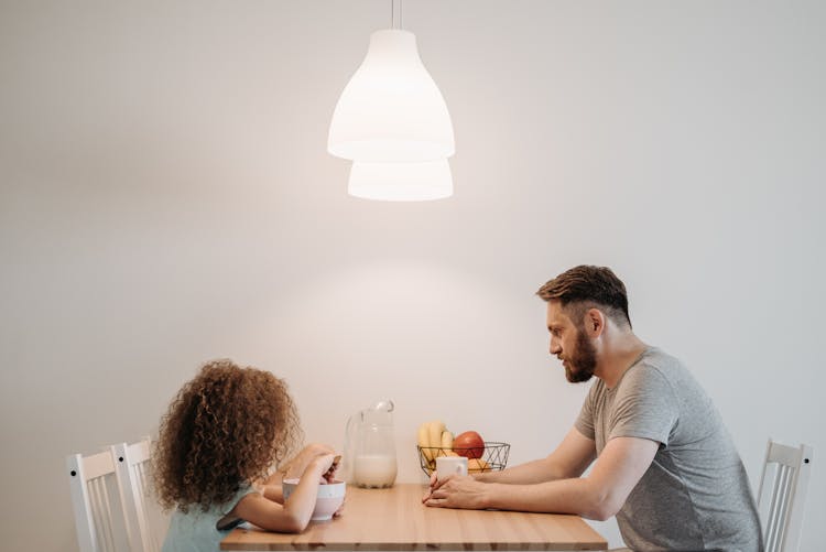 A Man Having Breakfast With His Child