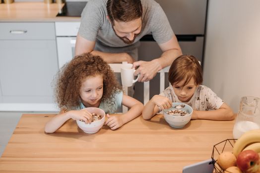 Father and children enjoying a hearty breakfast at home, creating a warm family moment.