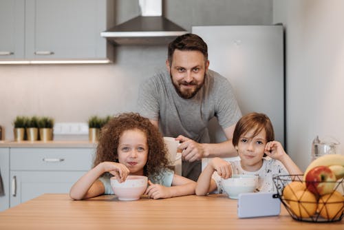 Man With His Children Smiling While Having Breakfast 