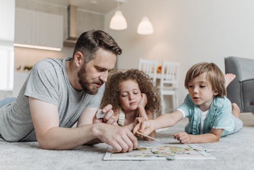 Man Solving a Puzzle with his Kids