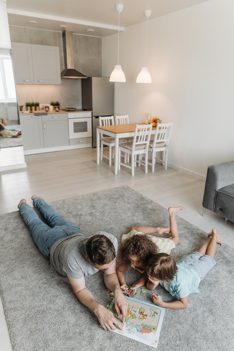 A Man And His Children Playing Puzzles Together