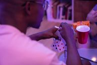 Man in Pink Shirt Holding White and Pink Polka Dot Textile