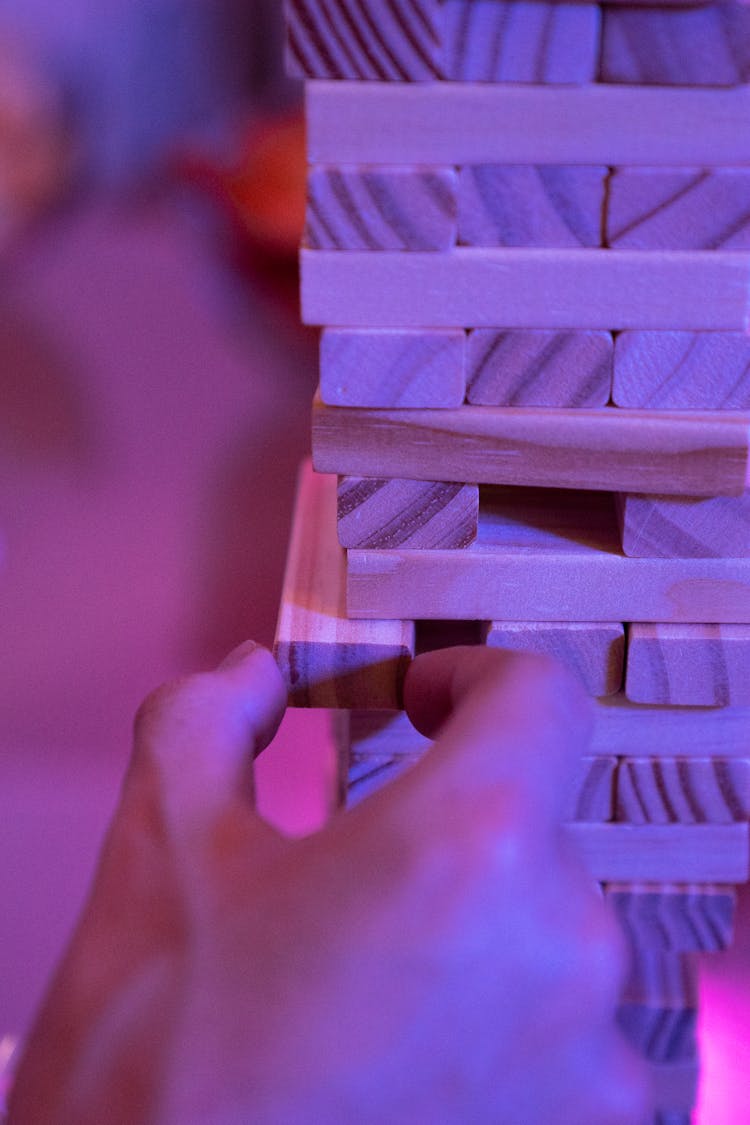 A Hand Getting A Piece Of Jenga