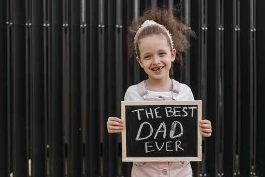 A Young Girl Holding a Blackboard