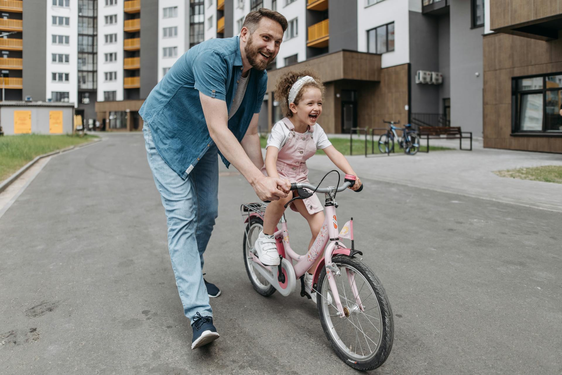 Father Guiding Her Daughter Riding a Bike