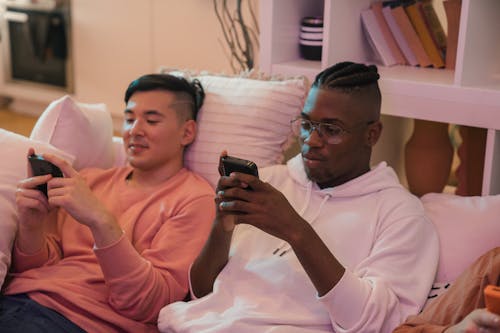 Men Sitting on the Couch Using Their Phones 