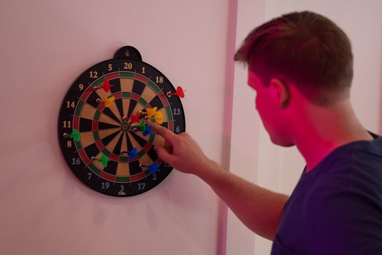 Man Counting Points From A Dart Game 