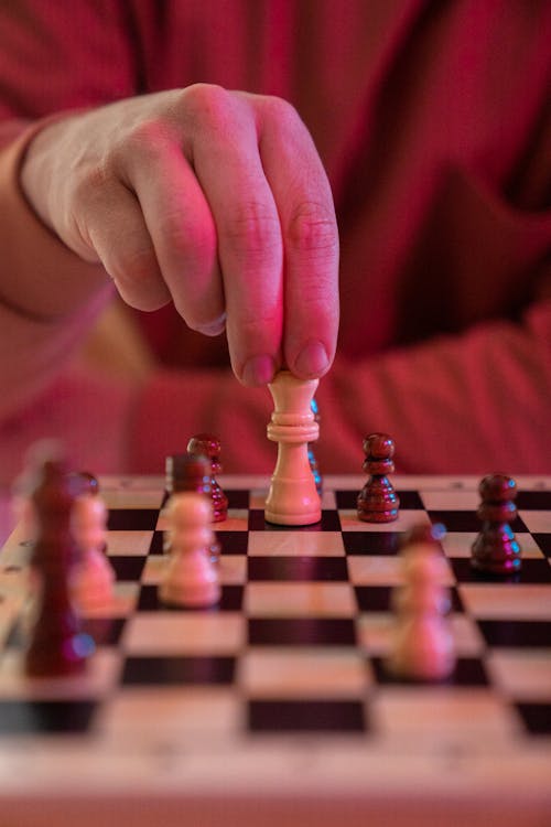 Person Holding A Chess Piece Making A Move