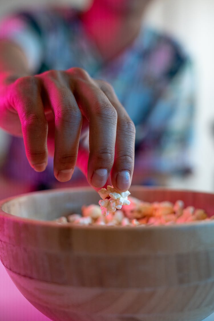 Hand Taking Popcorn From Bowl