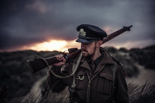 Close-Up Photography of a Man Holding Rifle