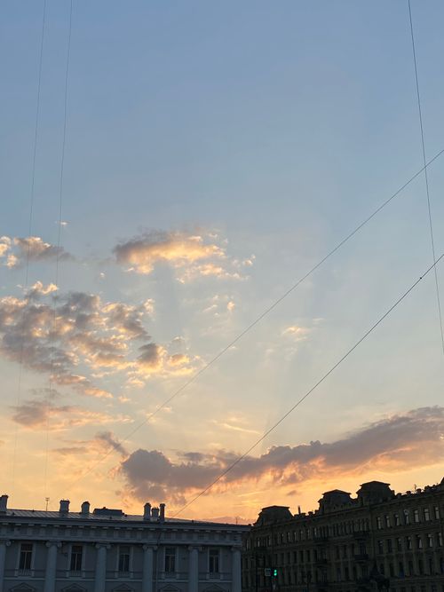 Free A stunning sunset over city buildings with vibrant clouds and clear sky. Stock Photo
