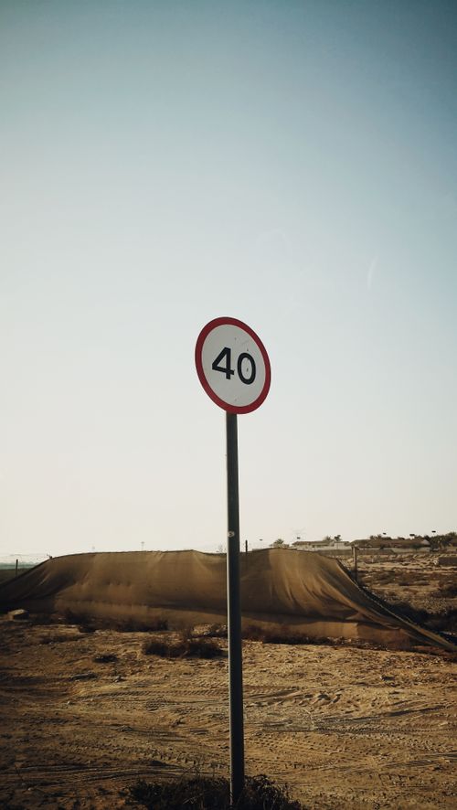 Free A speed limit sign reading 40 in the arid Dubai desert landscape. Stock Photo