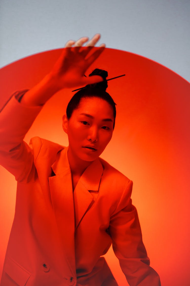 A Woman Behind An Orange Glass Panel