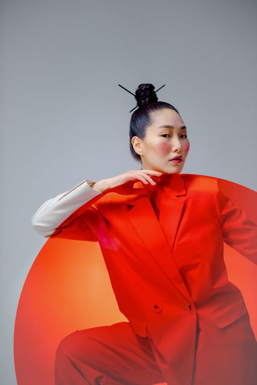 Free A stylish studio portrait of an Asian woman posing elegantly with red fashion elements and contemporary style. Stock Photo