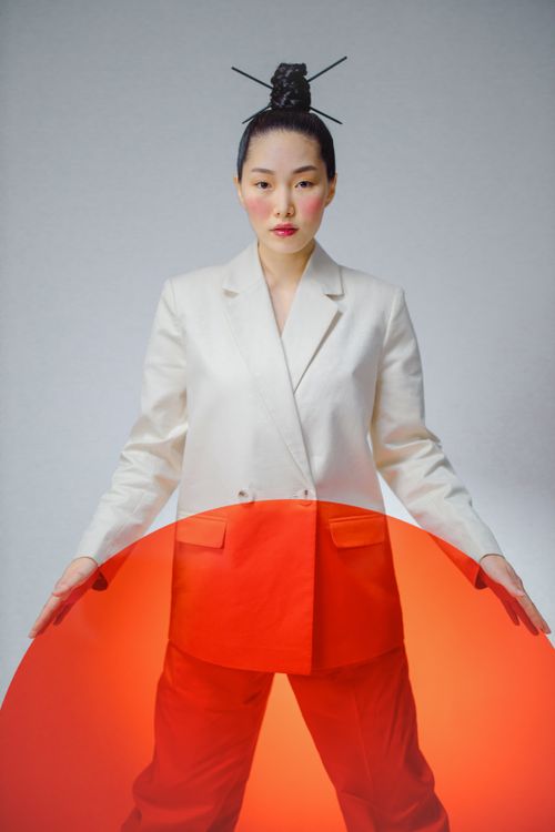 Free Elegant portrait of an Asian woman in a studio, styled with red and white conceptual fashion. Stock Photo