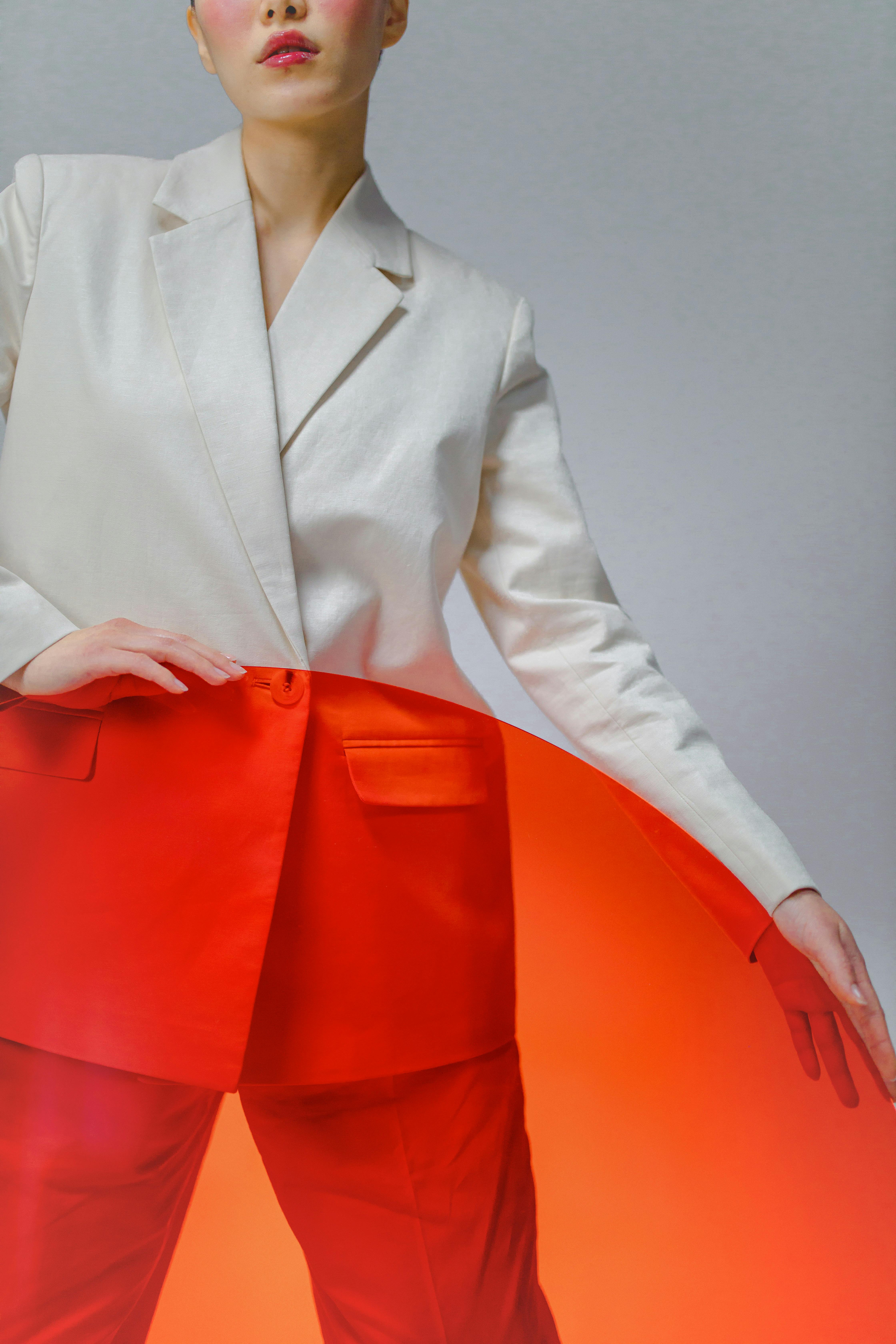 a woman in white suit holding a round glass panel