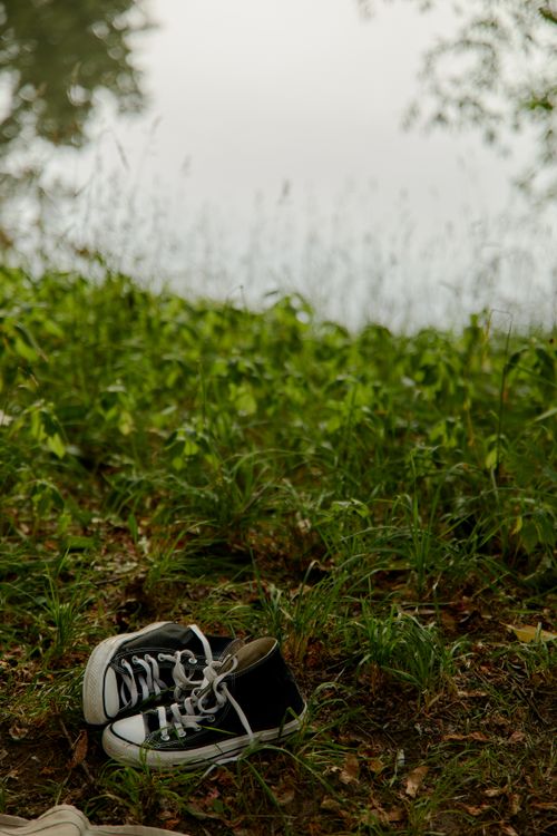Free A pair of black sneakers resting on lush green grass with a blurred background. Stock Photo