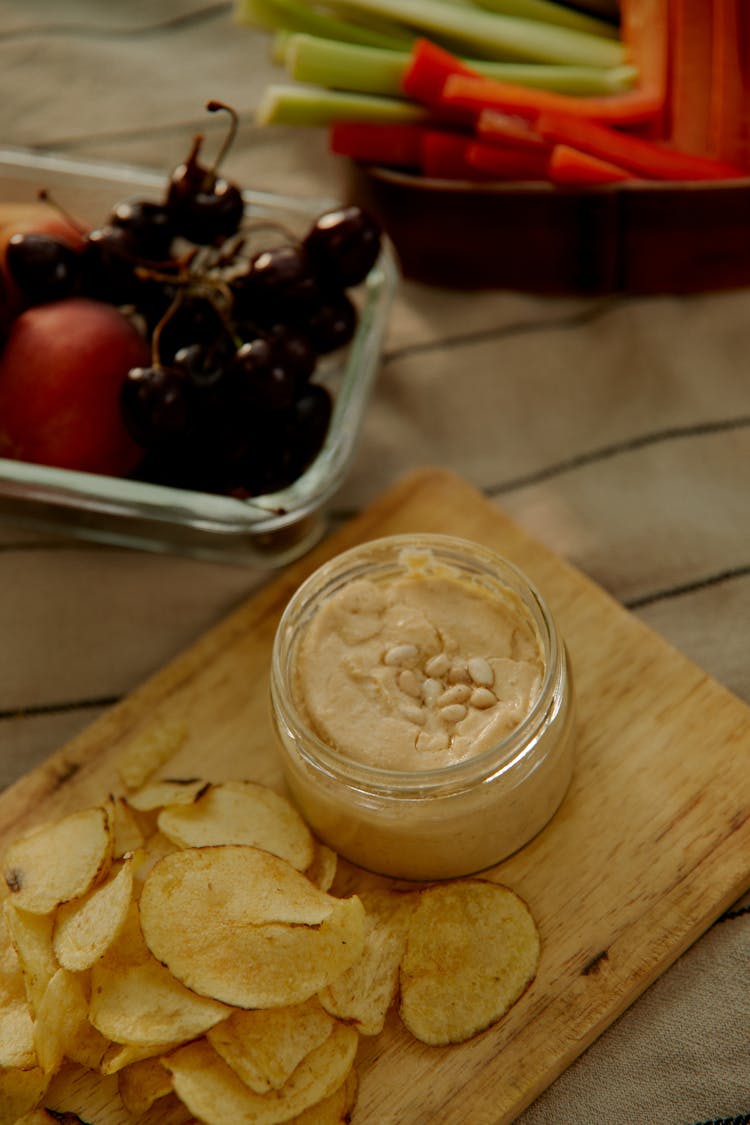 Fried Potato On A Wooden Chopping Board With Dip On The Side Beside The Small Tray Of Fresh Fruits And Vegetables