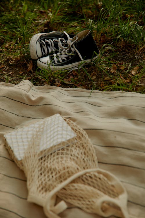 Free Black Converse Shoes Beside a Picnic Blanket Stock Photo