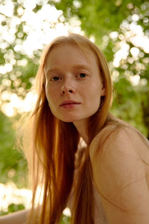 Free Gentle portrait of a woman with red hair in an outdoor setting, captured during daylight. Stock Photo