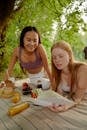 2 Women Sitting at Table Smiling