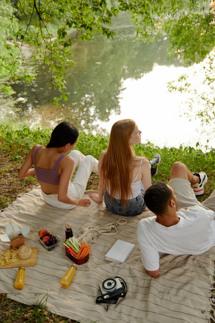 People Having A Picnic By The Lake