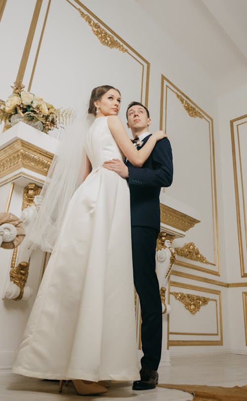 Woman Wearing White Sleeveless Bridal Gown Holding Man