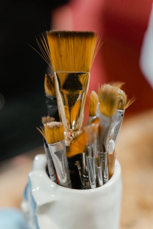 Free A variety of paintbrushes in a white ceramic holder, ideal for art and creativity themes. Stock Photo