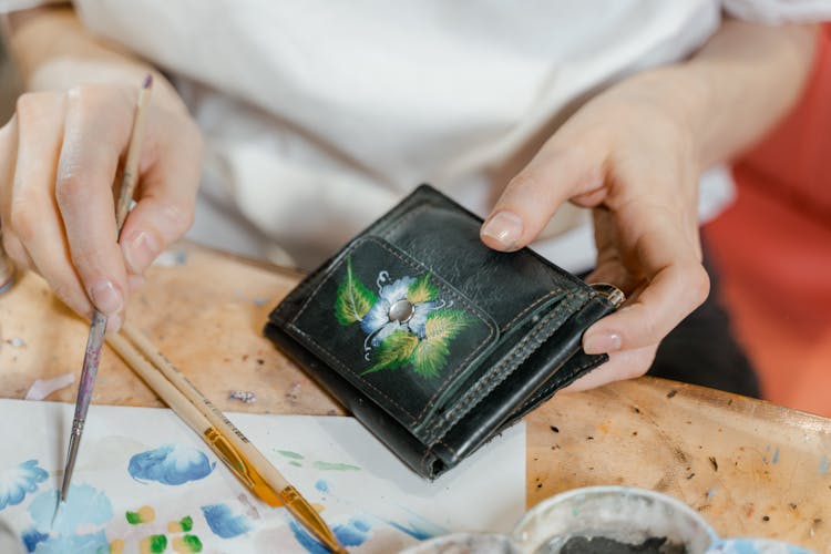 Person Holding A Black Leather Bifold Wallet