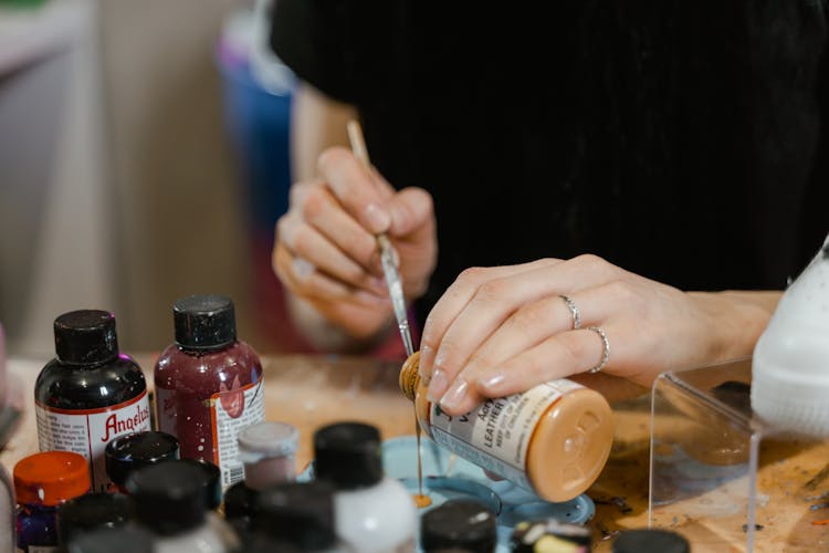 An Artist Pouring Acrylic Paint In A Palette Tray