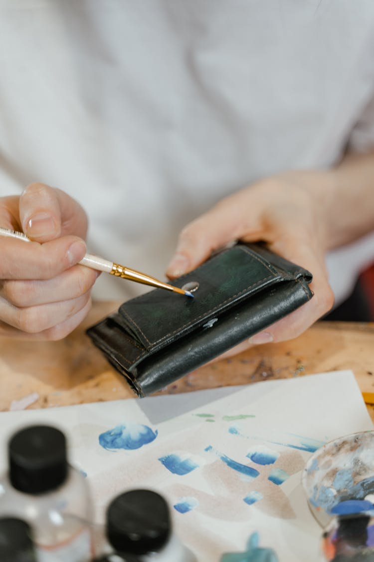 A Person Holding A Black Leather Wallet