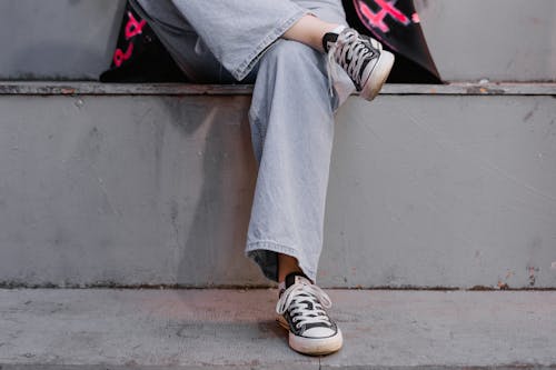 A Person Wearing Denim Legs and Black Sneaker Shoes