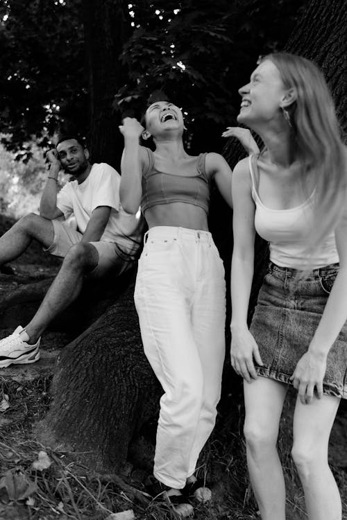 Grayscale Photo of Woman in White Tank Top and Blue Denim Skirts