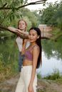 Woman in Blue Denim Jacket and White Denim Daisy Dukes Standing Near Green Tree